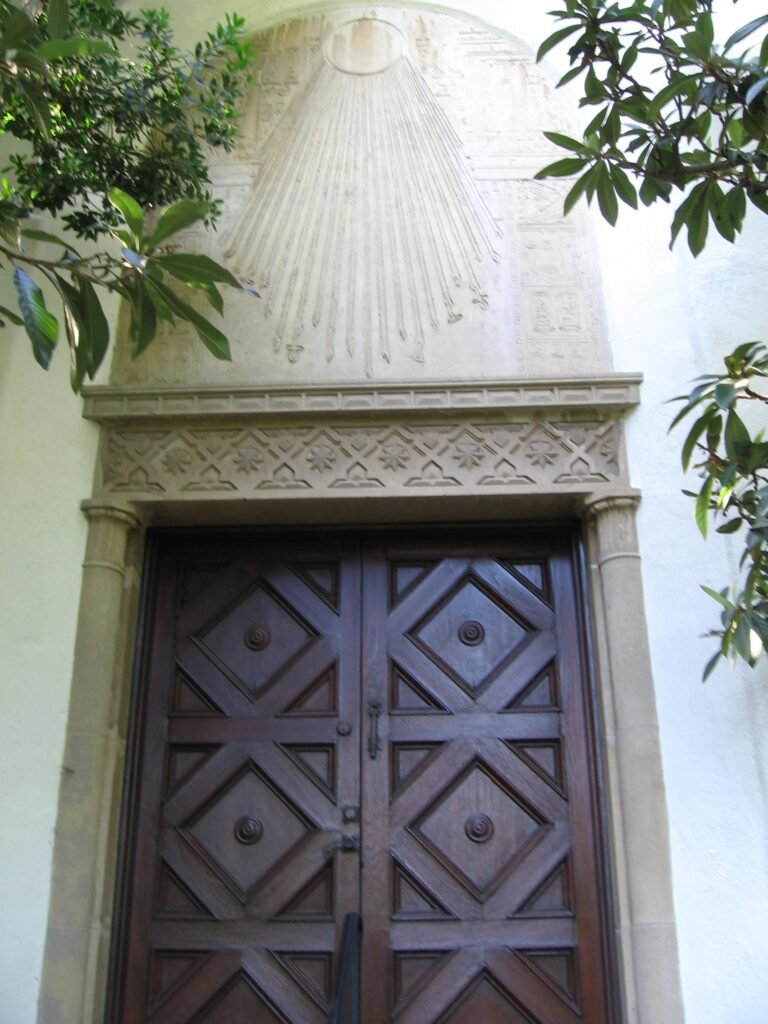 Mission-style entrance doors of Hale Solar Laboratory with carved sunburst relief above the lintel.