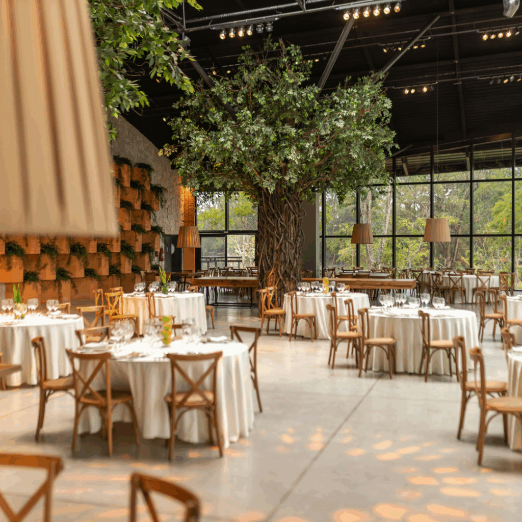 Indoor garden-style reception venue with tree centerpiece—ideal second location for a double destination wedding