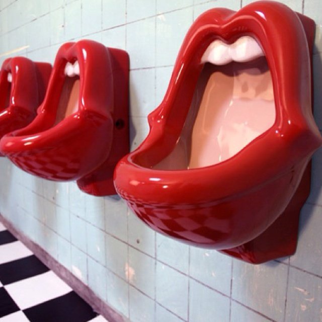 Row of Mick Jagger urinals—red lip-shaped fixtures at Tivoli Bar & Grill in San Diego