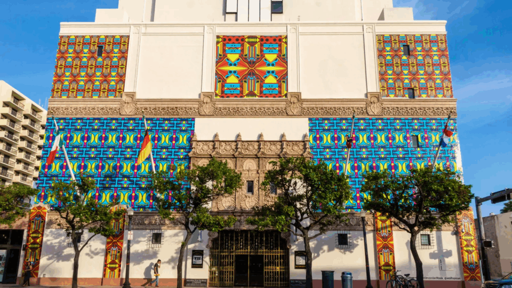 Exterior view of The Wolfsonian-FIU museum in Miami Beach with colorful Art Deco-inspired murals and ornate architectural details.
