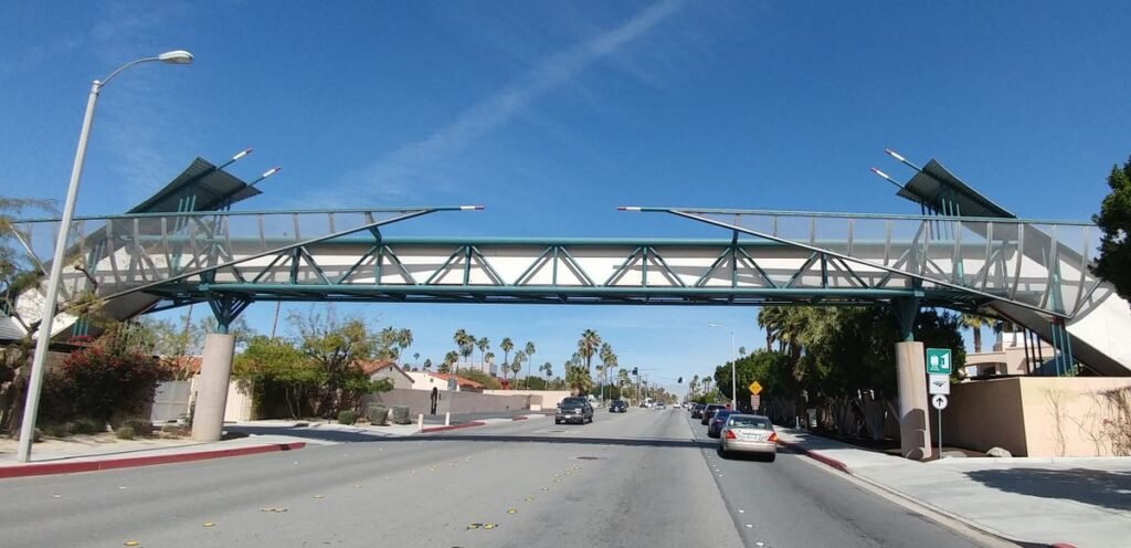 Baxandall Bridge Palm Springs pedestrian overpass spanning a city street with palm trees.