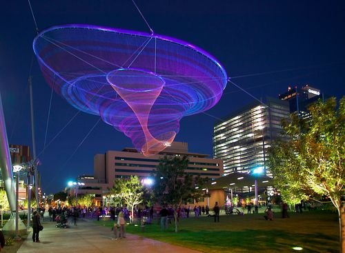 Her Secret Is Patience Phoenix glowing sculpture at night in Civic Space Park with downtown buildings in the background