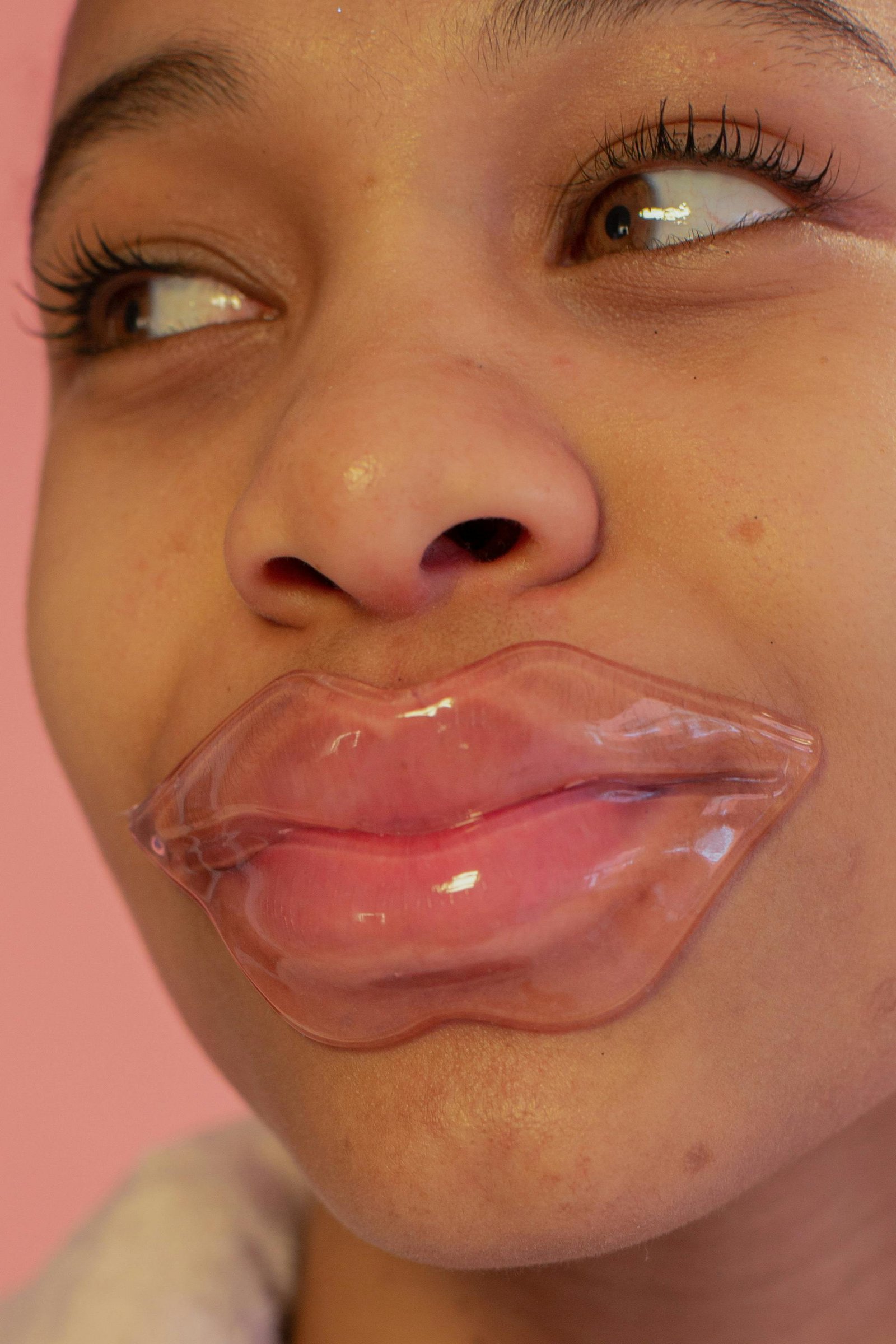 Woman using a lip mask treatment for hydration and plump lips.