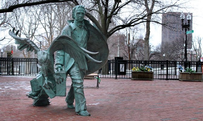Edgar Allan Poe statue with raven and suitcase at Poe Square Boston by Boston Common.