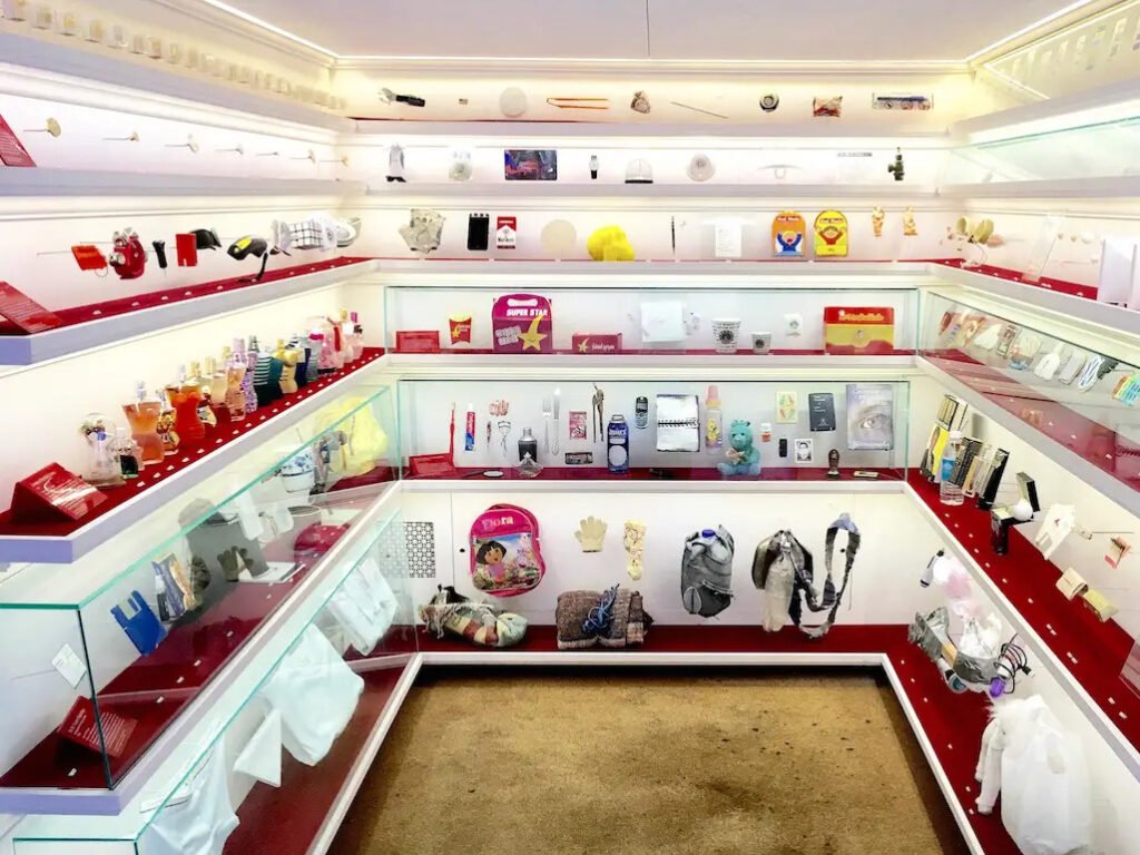 Interior view of Mmuseumm in New York, displaying quirky everyday objects in glass cases inside a former freight elevator.