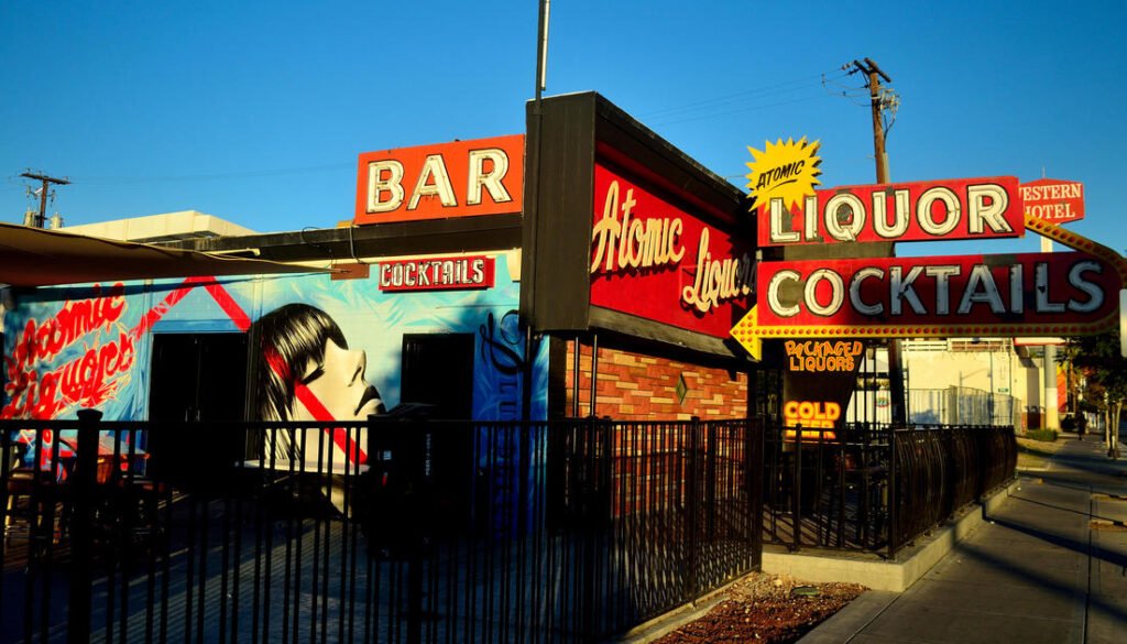Exterior of Atomic Liquors Las Vegas during the day with vintage neon bar and cocktail signs.