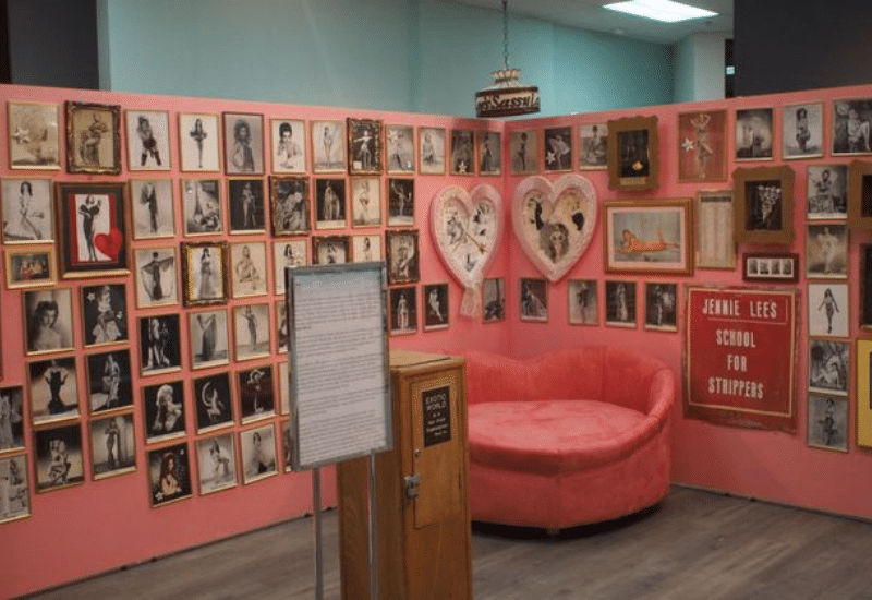 Interior exhibit at the Burlesque Hall of Fame in Las Vegas featuring vintage burlesque photos, heart-shaped displays, and Jennie Lee’s School for Strippers sign.