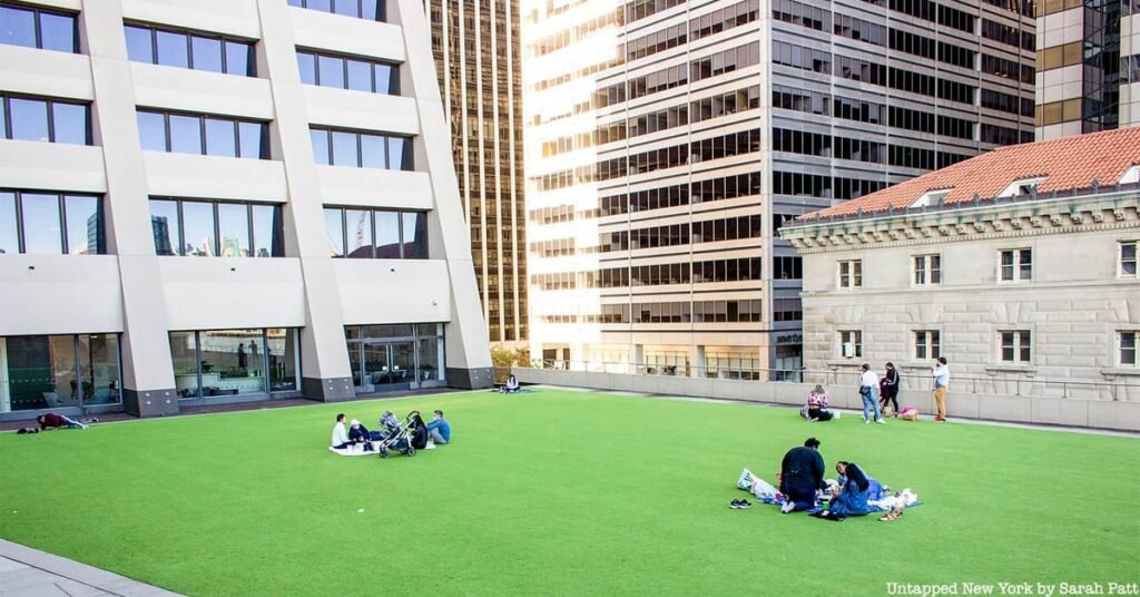 Visitors enjoying the tiered seating and skyline views at The Elevated Acre in New York, New York.