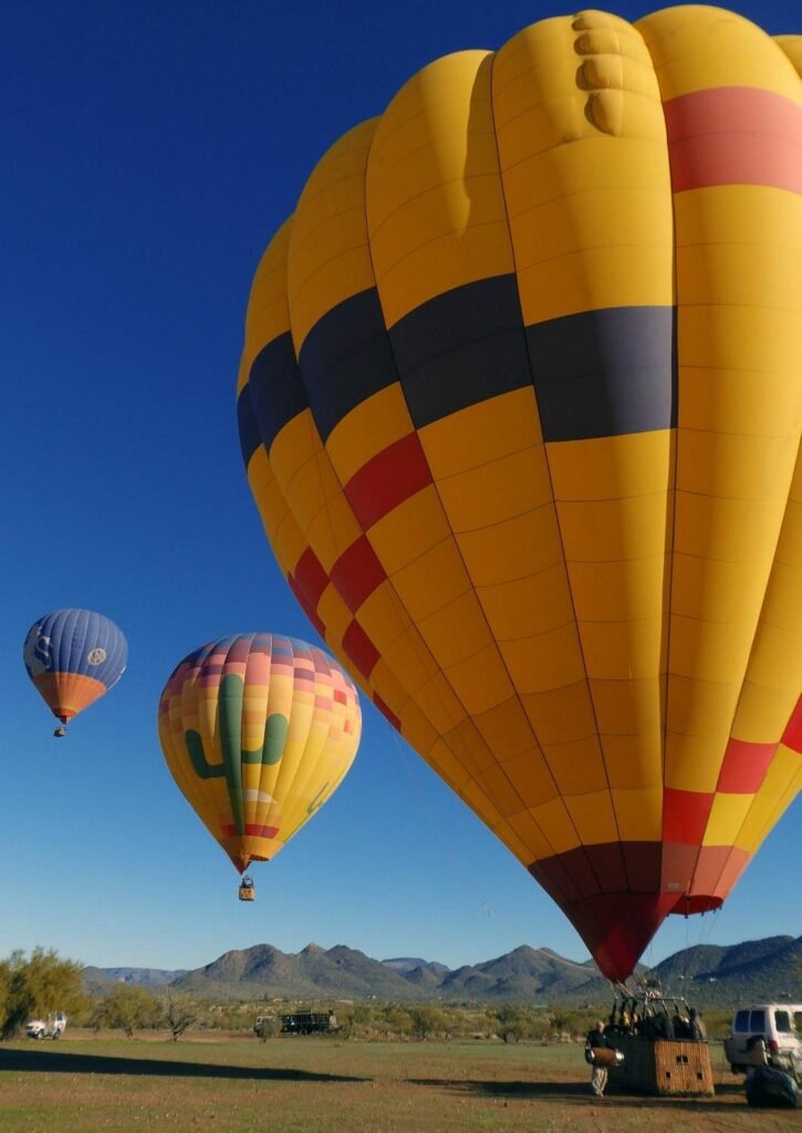 Colorful hot air balloons launching with desert mountains near Phoenix, Arizona.