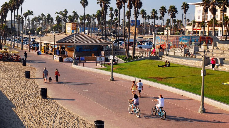 People biking along the Huntington Beach coastal path during a sunny weekend in Orange County.