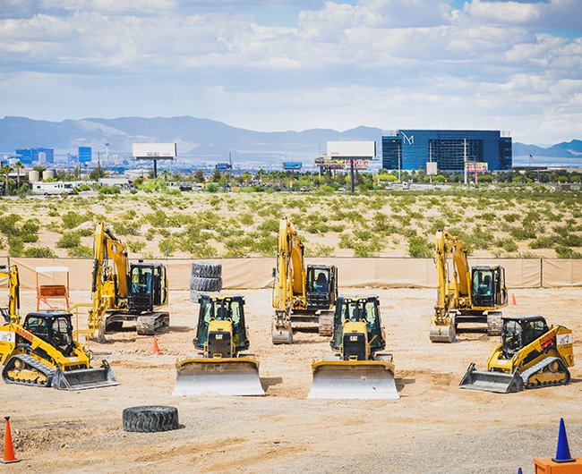 Bulldozers and excavators lined up at Dig This Las Vegas adult sandbox attraction.