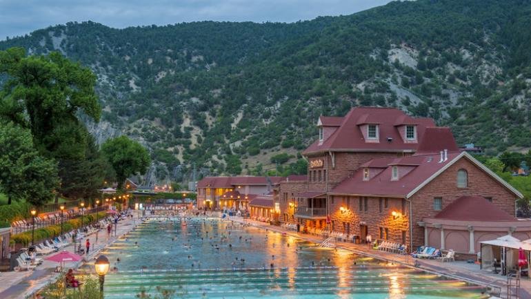 Glenwood Hot Springs Pool surrounded by mountains at sunset in Glenwood Springs, Colorado.