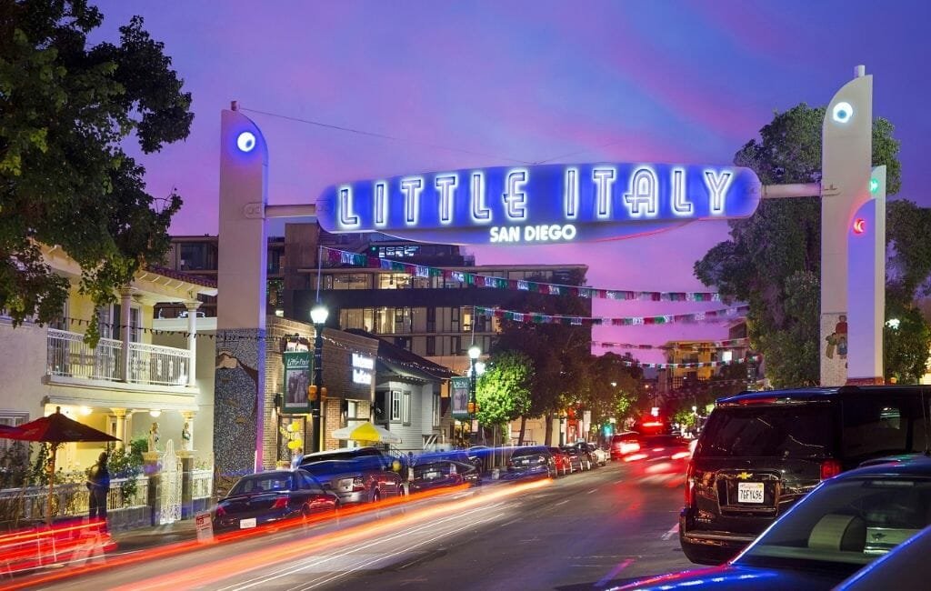 The iconic Little Italy sign glowing at dusk above the lively San Diego neighborhood.