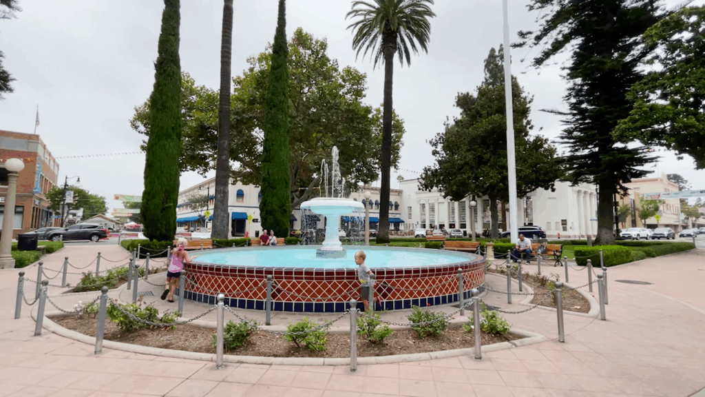 Central fountain and palm trees at Plaza Park in Old Town Orange, California.