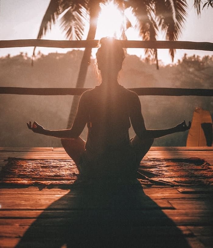 Yoga pose at sunrise in Palm Springs desert surrounded by golden light