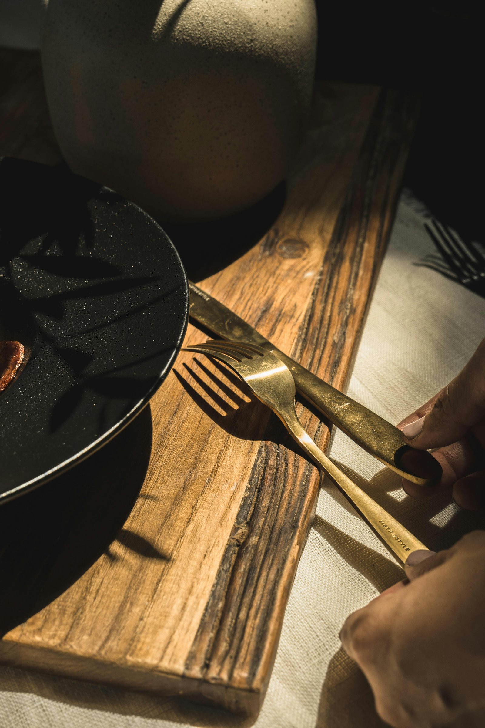 Rustic dining setup representing Denver breweries and food scene with gold cutlery on a wooden table.