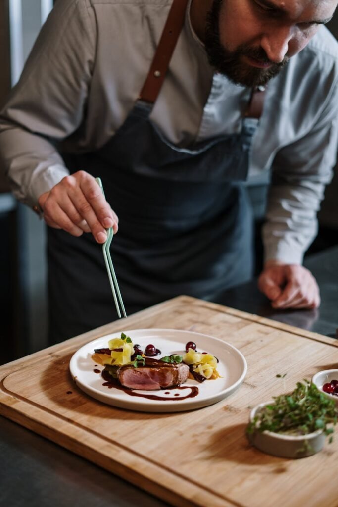 person holding fork and knife slicing vegetable on white ceramic plate