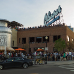 Exterior view of Linger Eatuary in Denver with rooftop diners and the historic Olinger Mortuaries sign