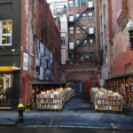 Outdoor book lot at Brattle Book Shop in Boston, surrounded by historic brick buildings and filled with carts of secondhand books.