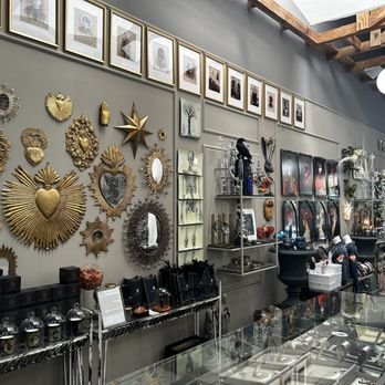 Gilded sacred-heart wall art, mirrors, and eclectic curios lining the interior of Gold Bug Pasadena in Old Town Pasadena.