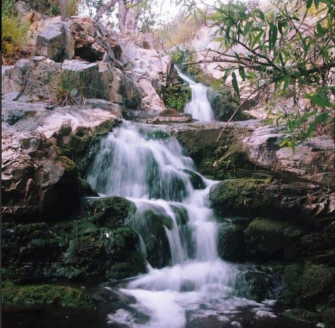 Long-exposure view of the multi-tier falls along the Copper Creek Falls and Mine trail, water streaming over green stone and boulders