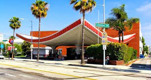 Iconic Union 76 Gas Station in Beverly Hills with its swooping mid-century canopy framed by palm trees on a sunny day