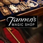 Close-up display of magic coins, medallions, and a brass key on red velvet at Tannen’s Magic Shop New York