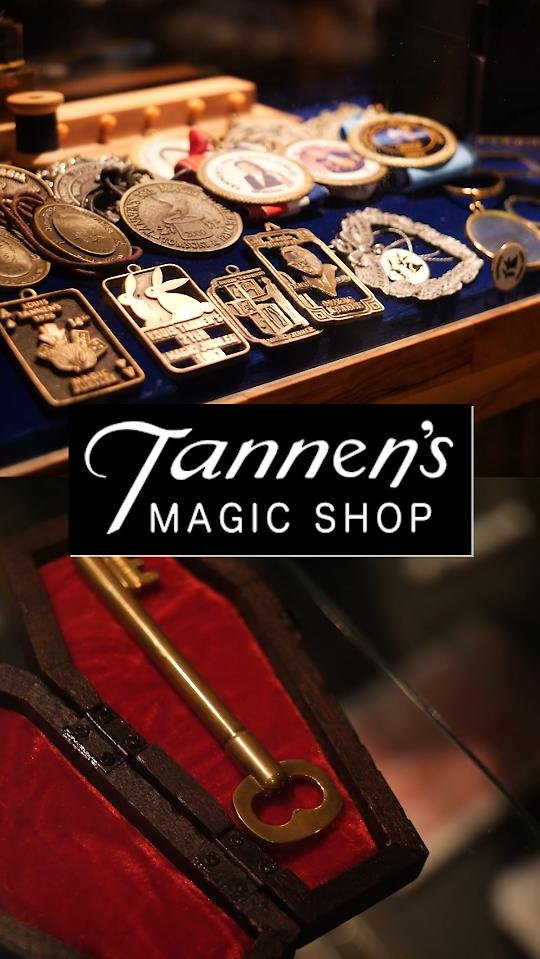 Close-up display of magic coins, medallions, and a brass key on red velvet at Tannen’s Magic Shop New York