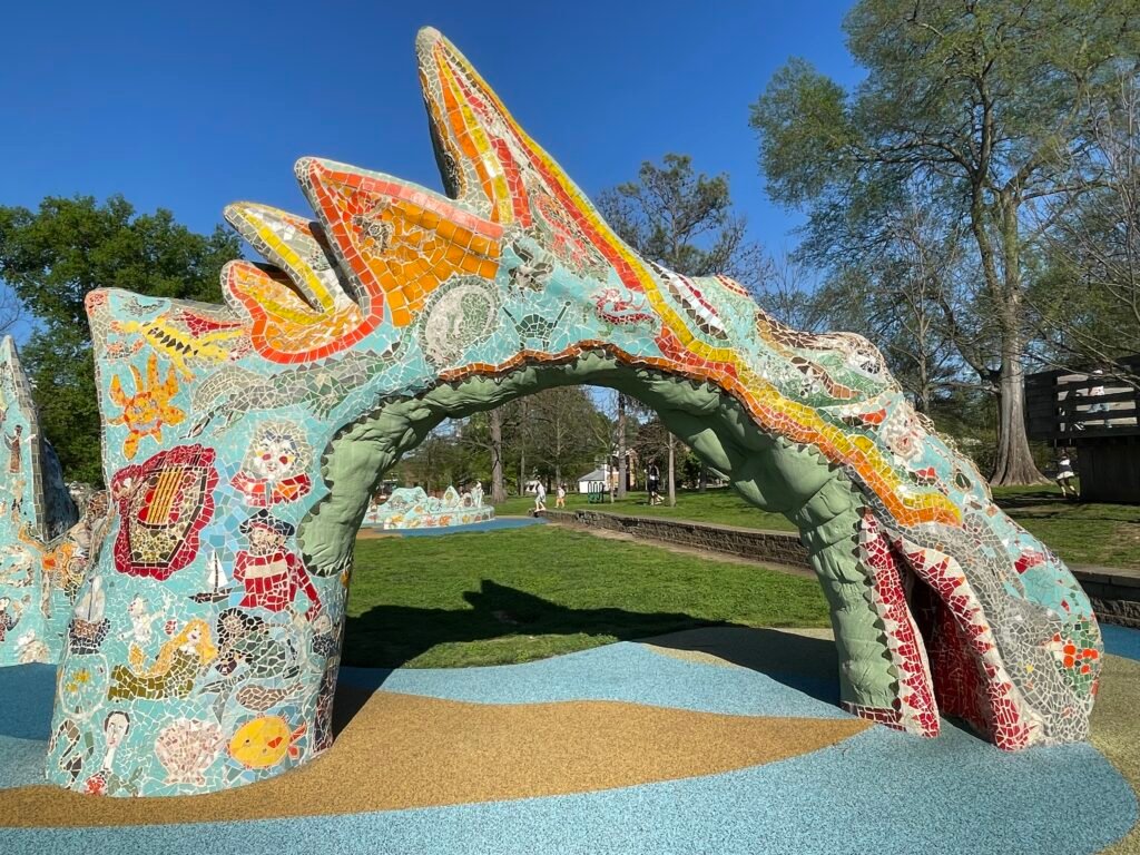 Close-up of the Sea Serpent sculpture’s head, showcasing vibrant mosaic tile details and its graceful arch at Dragon Park Nashville