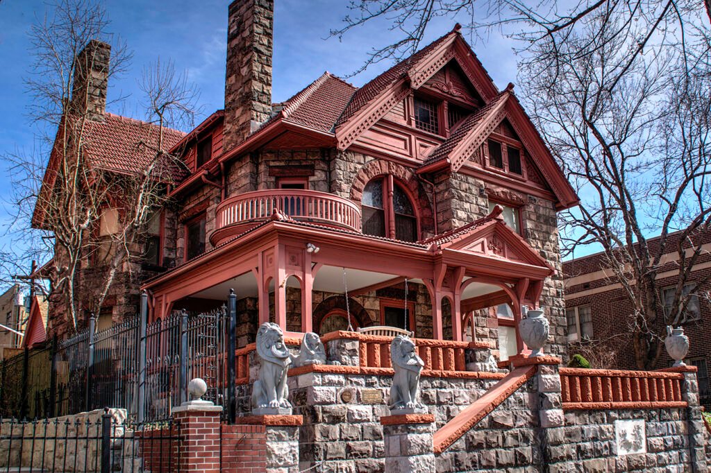 Daytime view of the Victorian-style Molly Brown House Museum with lion statues and red-trimmed porch