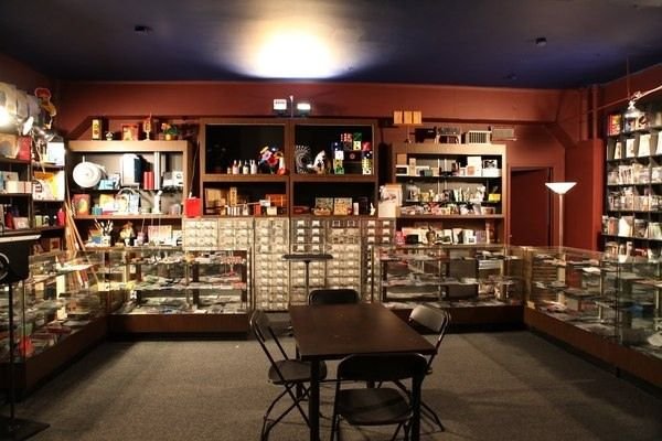 Interior of Tannen’s Magic Shop New York showing glass display cases filled with wands, cards, and props around a central demo table
