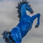 Blue Mustang Denver statue rearing against a cloudy sky outside Denver International Airport
