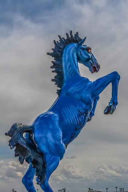 Blue Mustang Denver statue rearing against a cloudy sky outside Denver International Airport