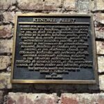 Historical plaque on the brick wall marking Kendall Alley in Pasadena, California, describing its significance and original developer.