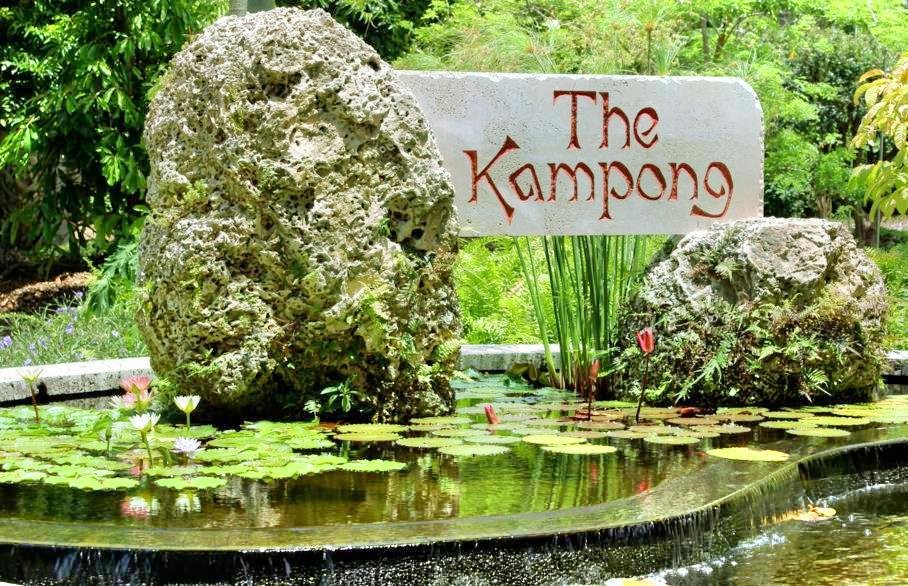 Stone archway at The Kampong Miami opening onto Biscayne Bay, surrounded by lush tropical plants