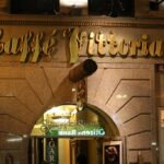 Night view of the gold-lettered Caffe Vittoria Boston storefront in the North End