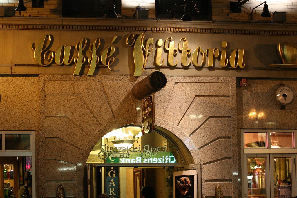 Night view of the gold-lettered Caffe Vittoria Boston storefront in the North End