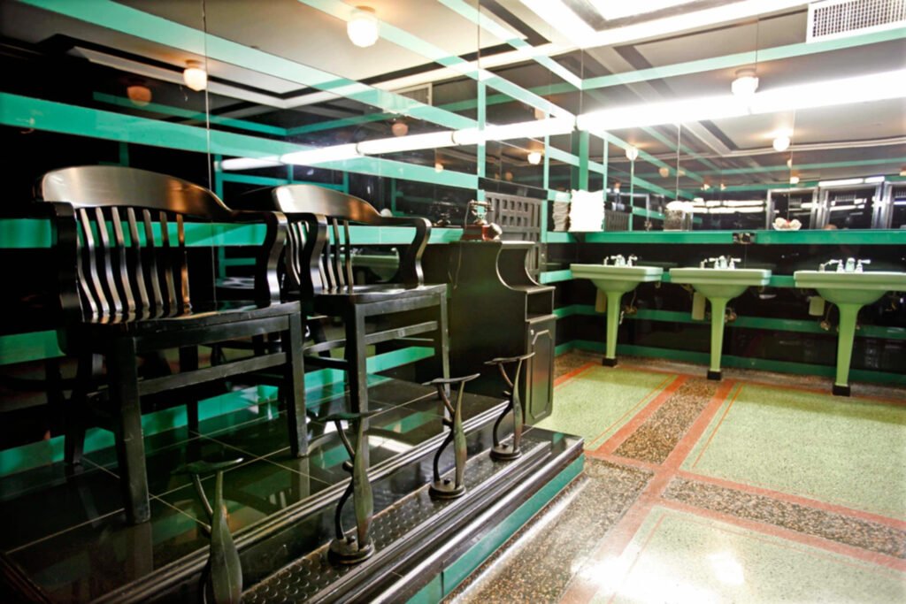 Shoe-shine stand and emerald pedestal sinks inside the Art Deco men’s bathroom at Nashville’s Hermitage Hotel.