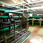 Shoe-shine stand and emerald pedestal sinks inside the Art Deco men’s bathroom at Nashville’s Hermitage Hotel.