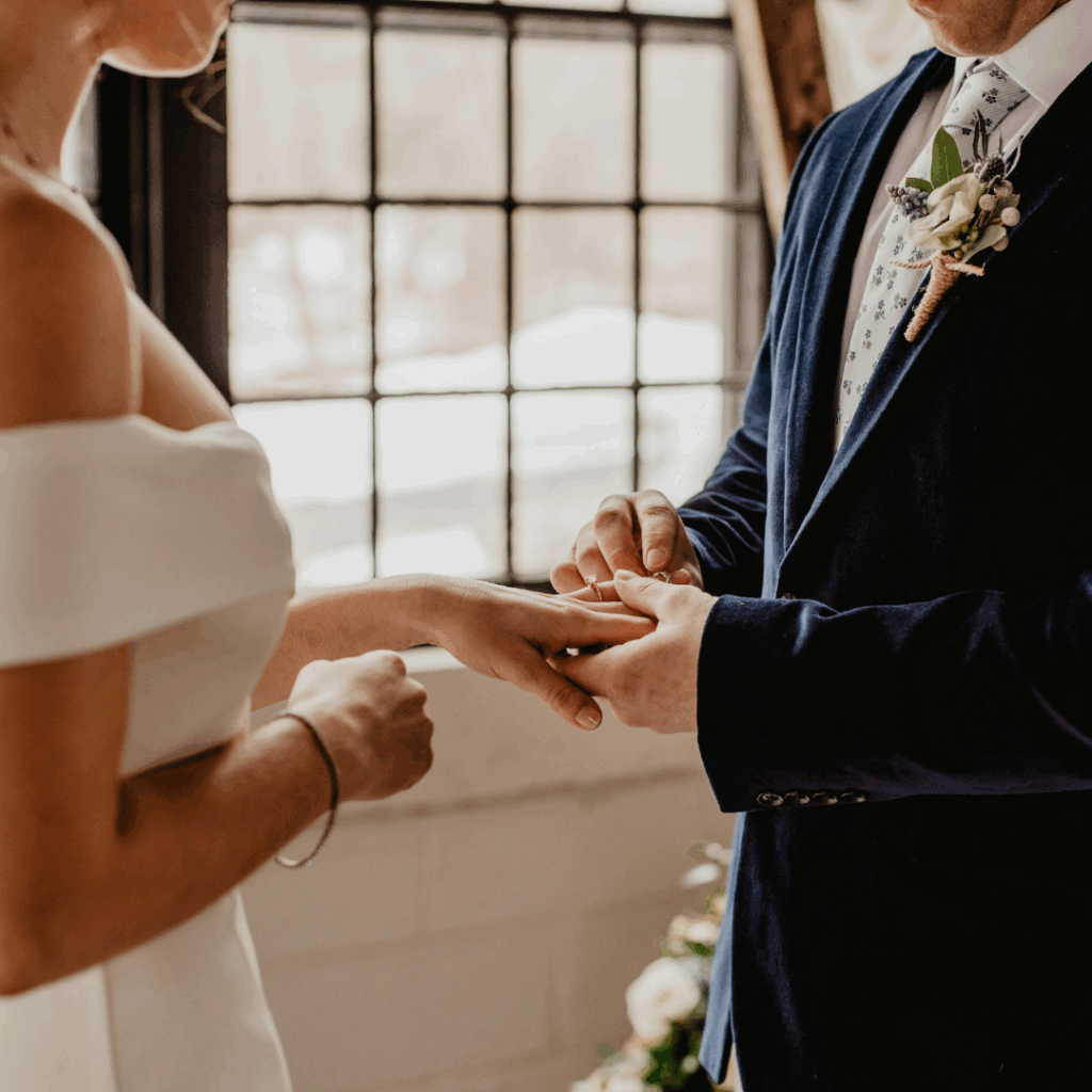 Couple exchanging rings in intimate loft ceremony—perfect vibe for weekday weddings