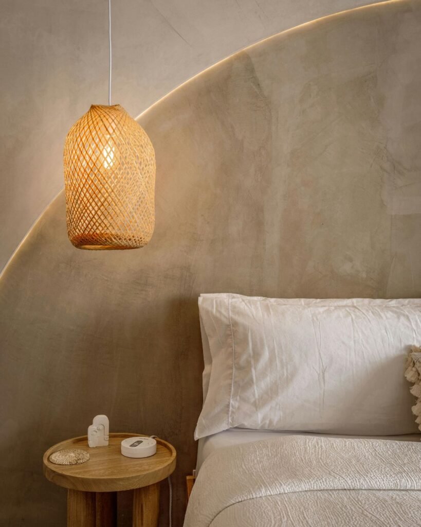 Warm neutral bedroom featuring a cozy bed, woven pendant light, and nightstand decor — a perfect example of cozy bedroom essentials in a minimalist style.