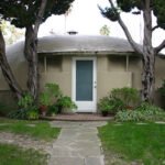 Front view of the original 1946 Bubble House Pasadena framed by cypress trees
