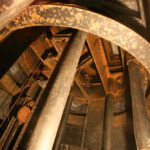 Rust-flecked gear mechanism and support columns inside the rotating dome of Hale Solar Laboratory.