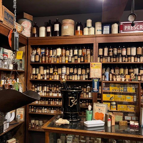 Apothecary shelves of medicine bottles at Ruddy's General Store Museum Palm Springs, complete with Rx mortar