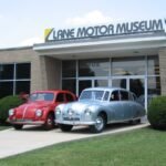 Entrance of Lane Motor Museum, Nashville, flanked by two vintage cars
