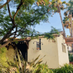 Exterior view of The Luggage Room Pasadena surrounded by palm trees and greenery