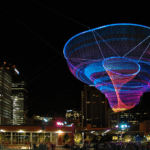 Her Secret Is Patience Phoenix sky sculpture above Civic Space Park with people gathered in the evening