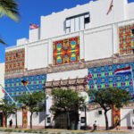 Street view of The Wolfsonian-FIU in Miami Beach, showcasing its vibrant patterned murals and historic building design.