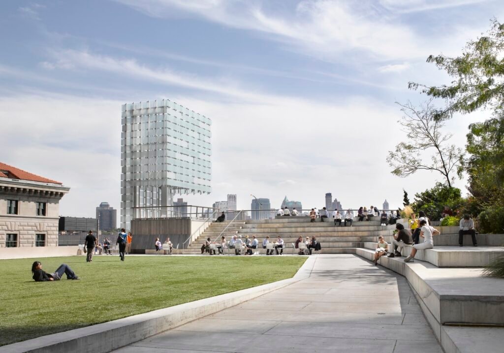 People relaxing on the lawn at The Elevated Acre in New York, New York, a hidden rooftop park in the Financial District.