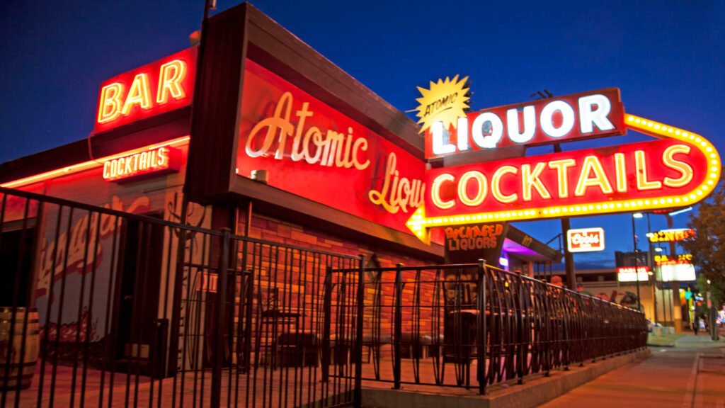 Atomic Liquors Las Vegas glowing neon signs at night highlighting cocktails and liquor.